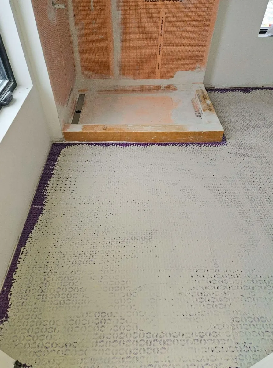 Fond de douche et murs imperméabilisés à la membrane, avec drain linéaire, avant la pose de la céramique