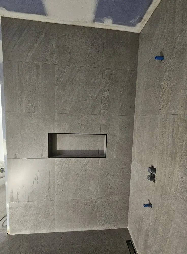 Mur de douche en 24 x 24 : alcôve alignée sur les joints, coupes nettes autour des sorties de plomberie