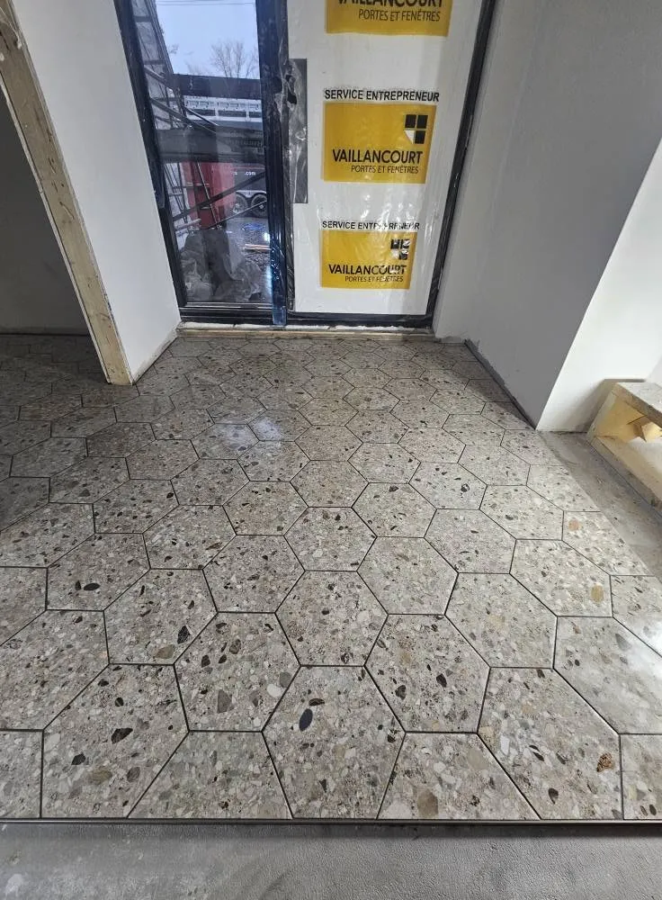 Entrée en carreaux hexagonaux, posée jusqu'au seuil de la porte
