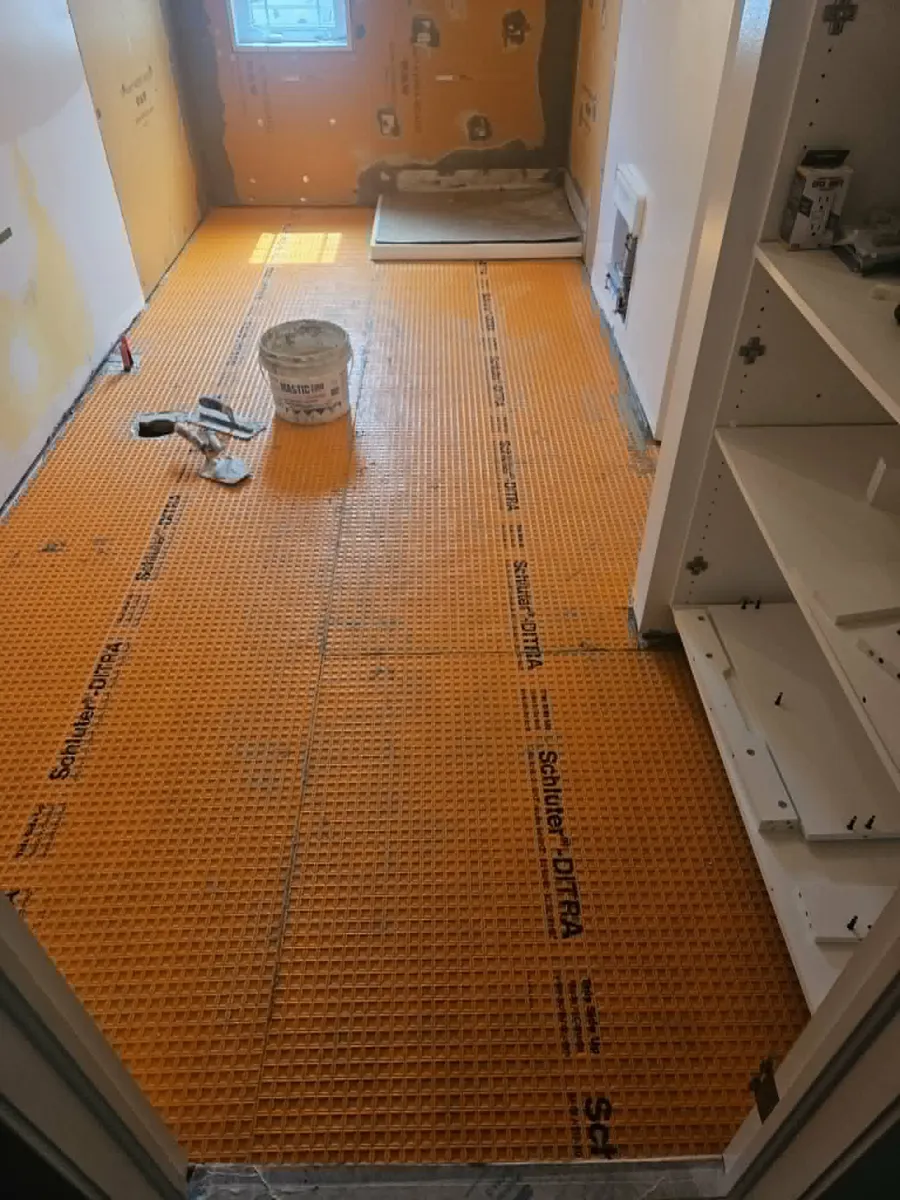 Membrane Ditra posée sur tout le plancher de la salle de bain avant la céramique