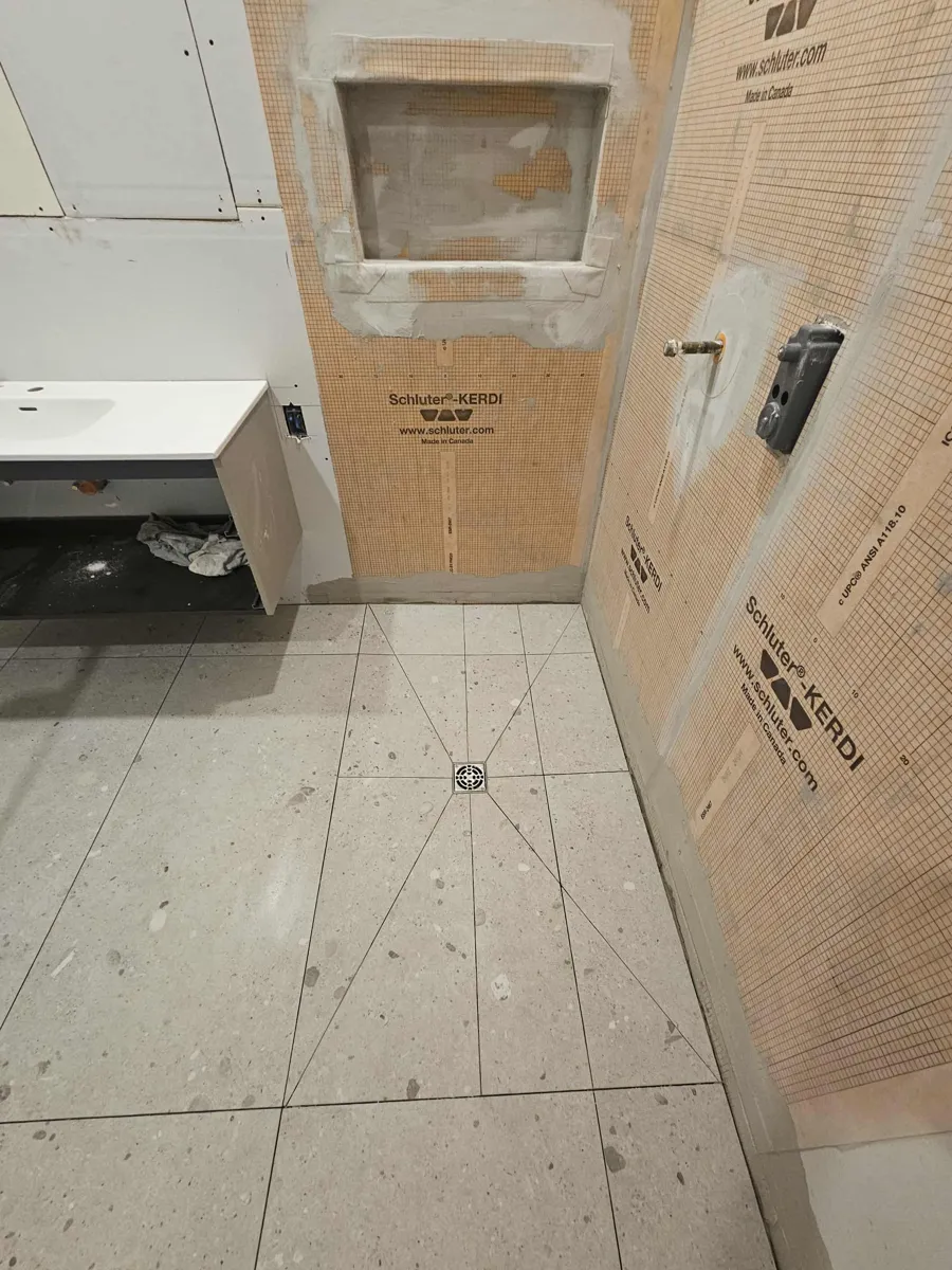 Murs de douche imperméabilisés à la membrane Kerdi et plancher en pente vers le drain central