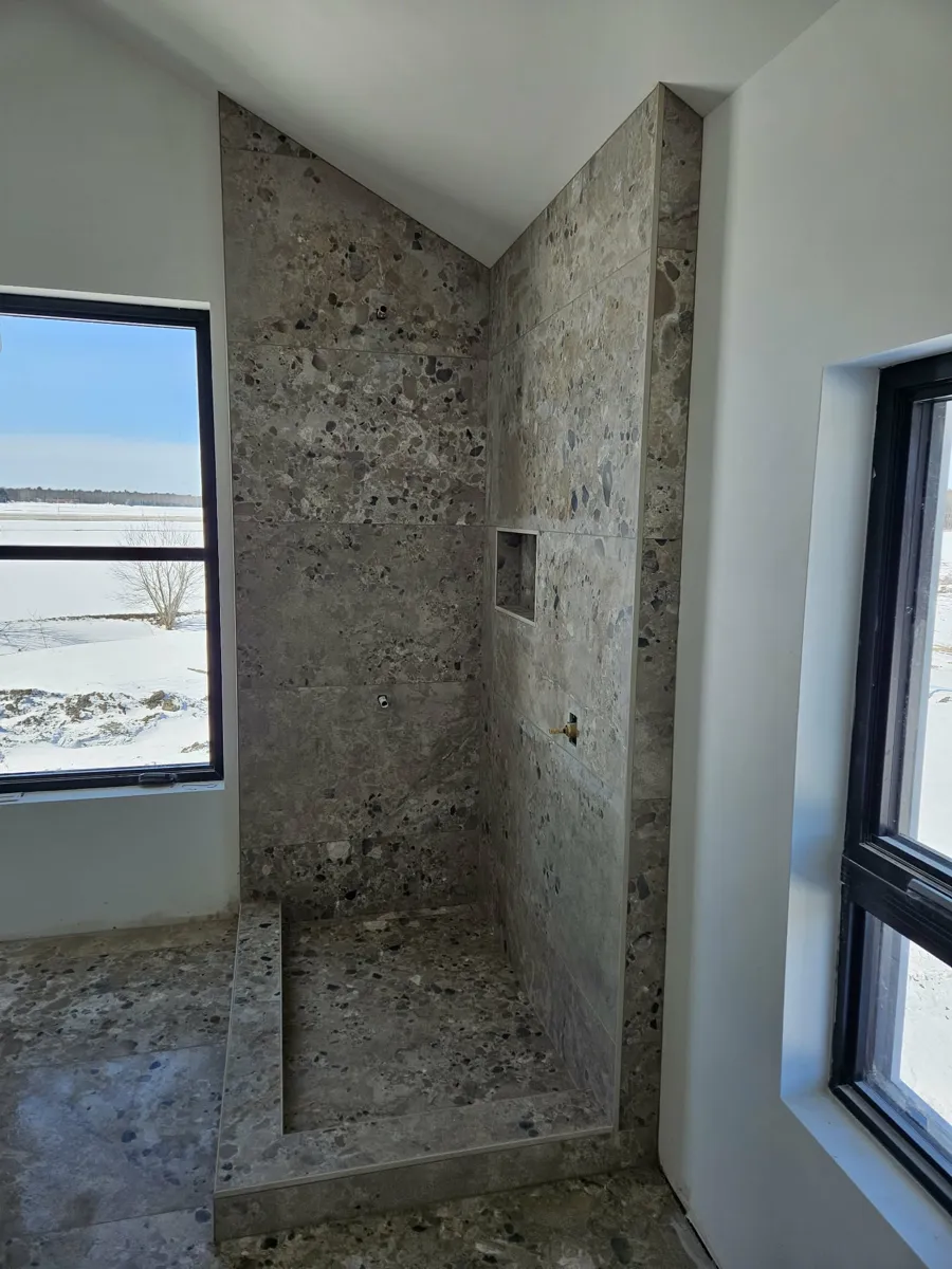 Douche en terrazzo gris-taupe avec niche intégrée et margelle